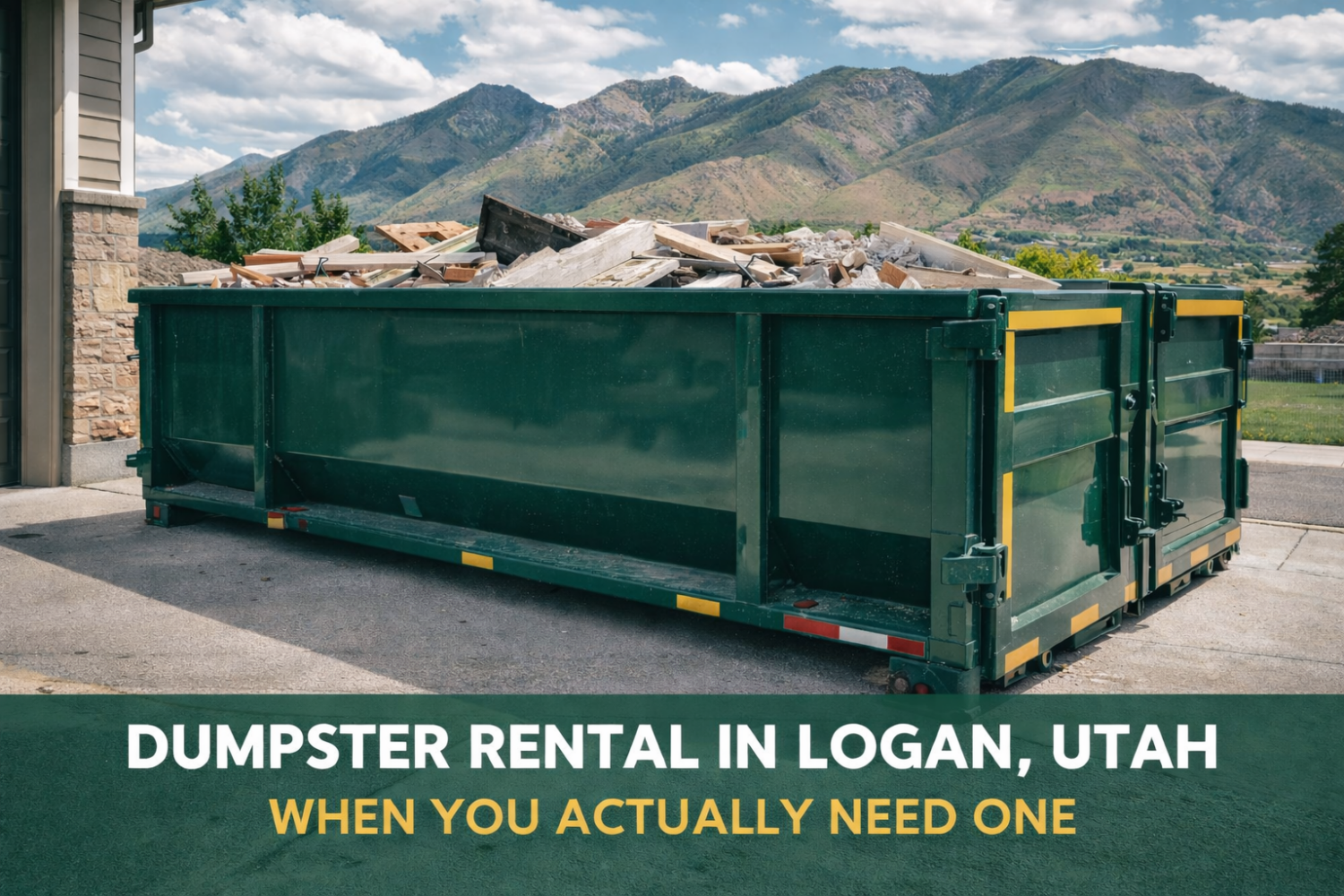 Green roll-off dumpster filled with construction debris in a residential driveway in Logan, Utah with mountains in the background during a home renovation cleanup.
